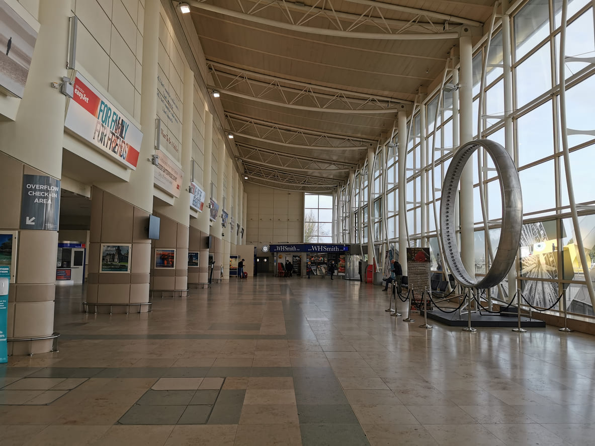 The terminal at Liverpool John Lennon Airport showcases a bright, spacious interior with modern design and prominent structural details.