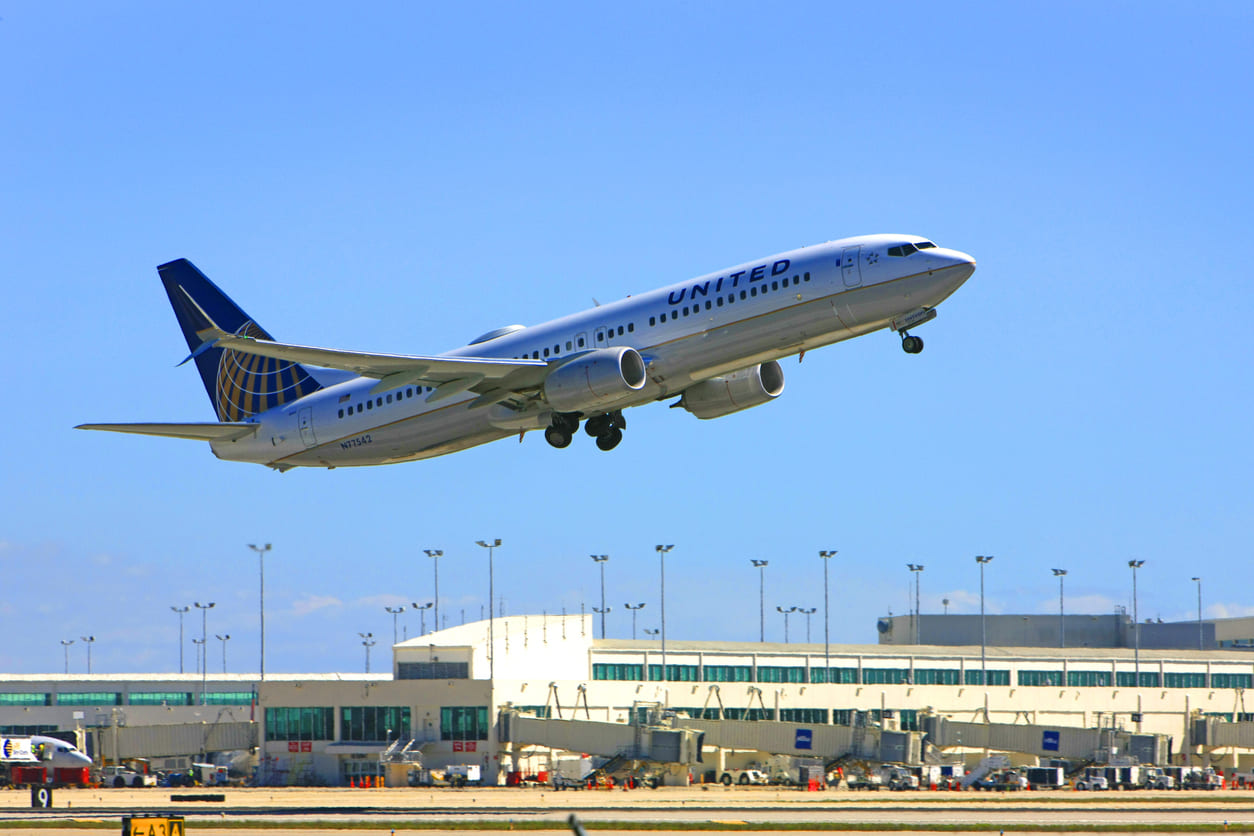 A United Airlines aircraft is captured mid-takeoff at Southwest Florida International Airport, with the terminal in the background.