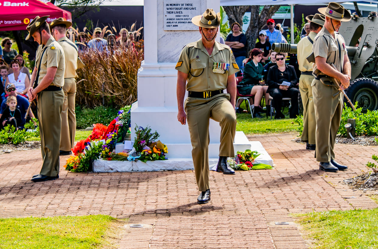 Australian soldiers honor ANZAC Day with a ceremonial tribute at a war memorial.