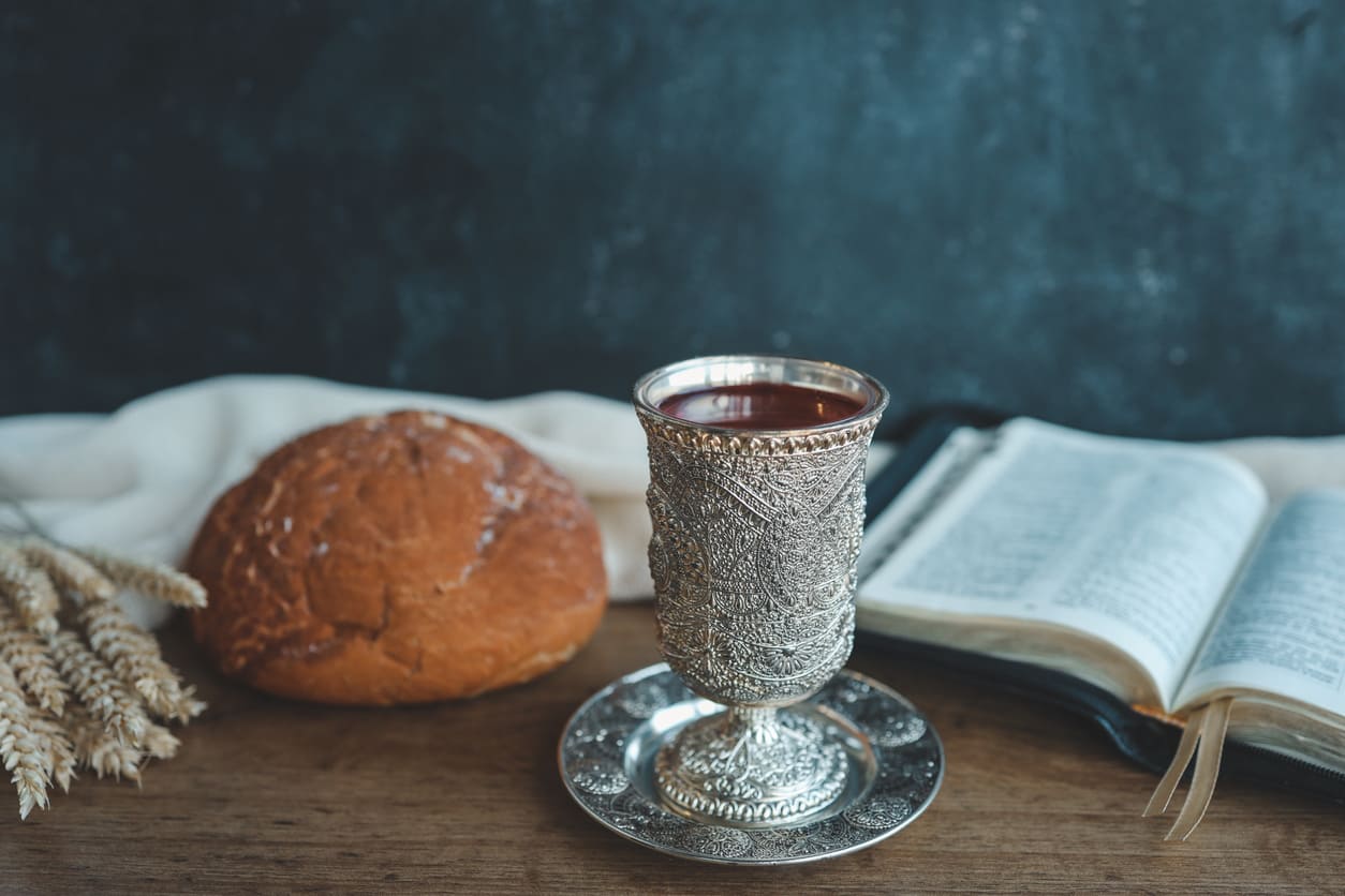 A silver chalice, crimson wine, and Bible—sacred symbols of Corpus Christi's holy communion.