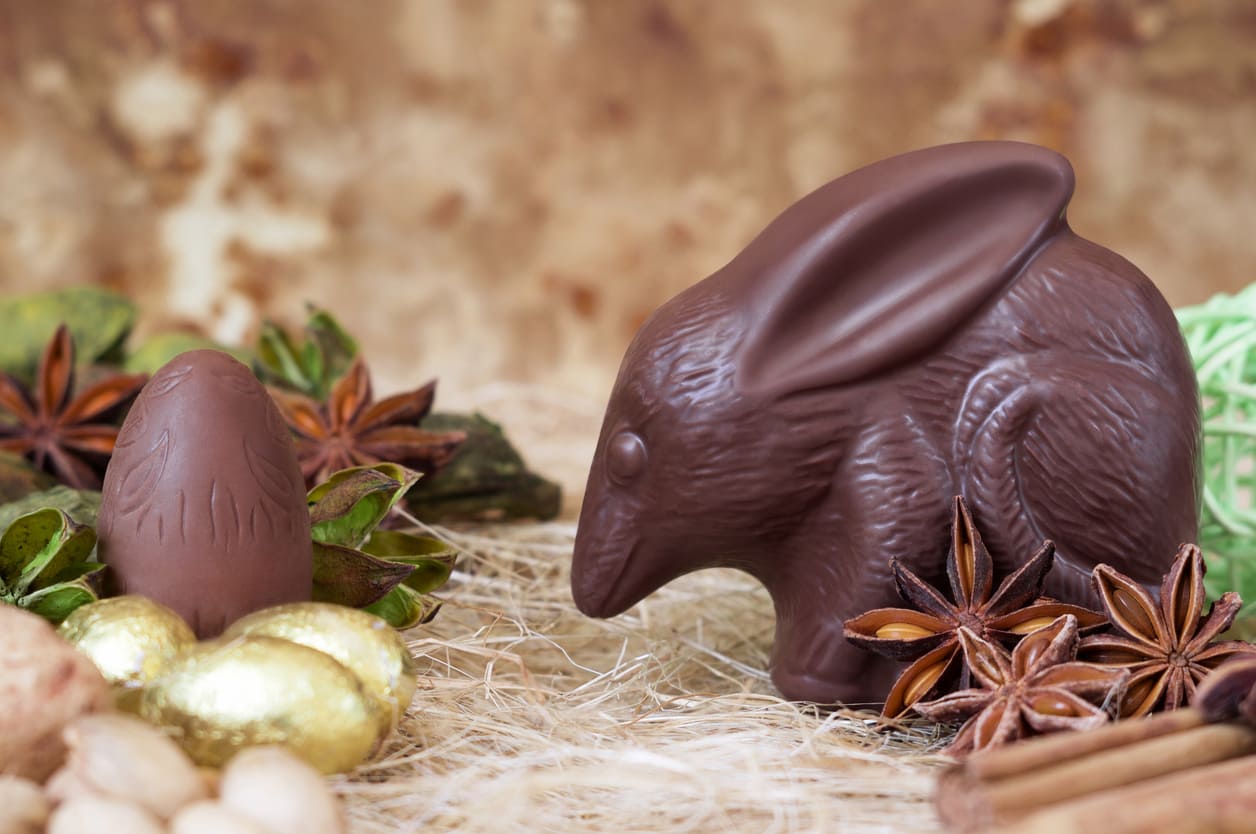 A chocolate Easter bilby sits beside decorated eggs and spices, reflecting Australia's unique Easter traditions and celebration of native wildlife.
