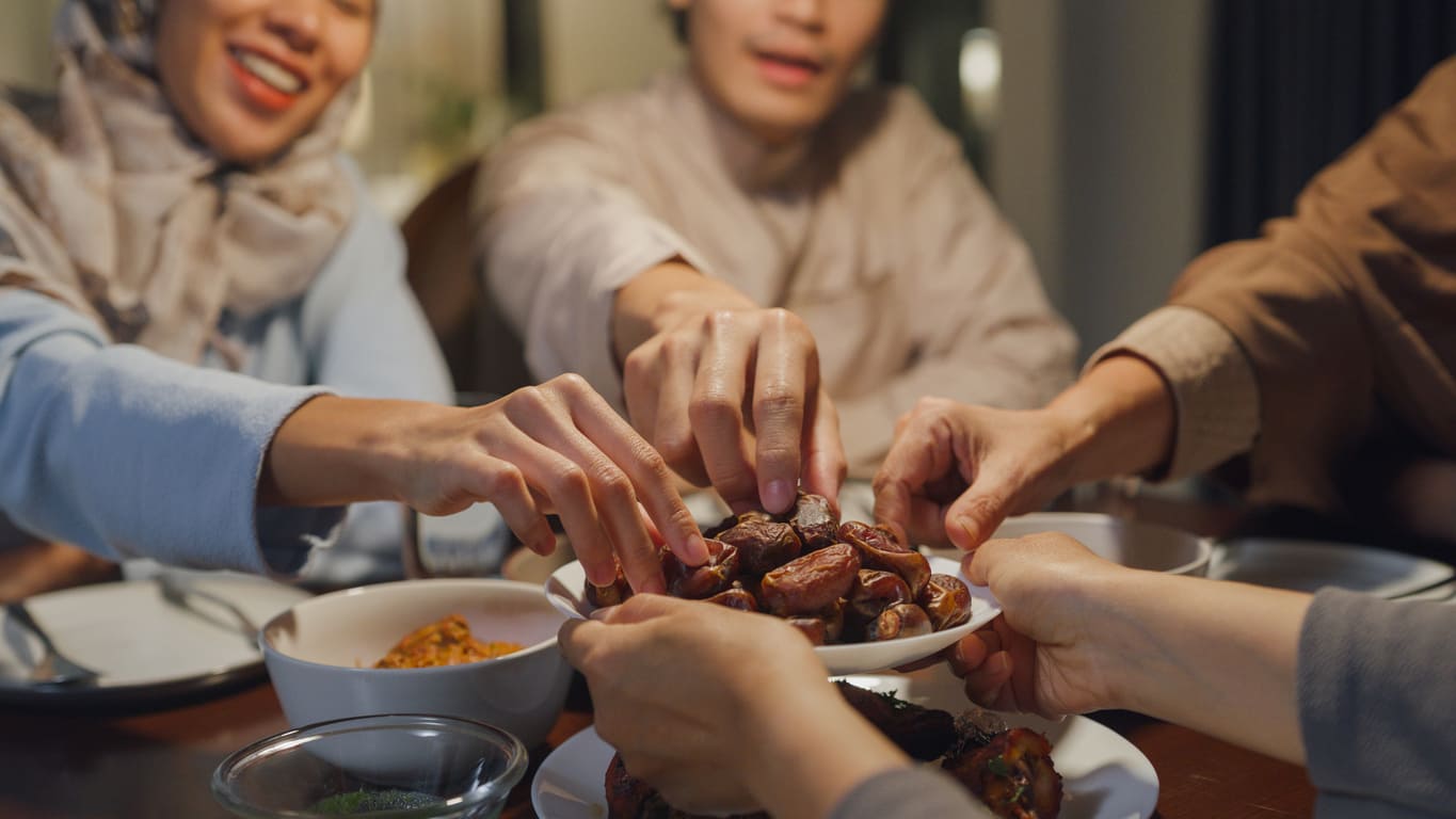 Family and friends share dates together, capturing a warm moment of togetherness during a festive meal.