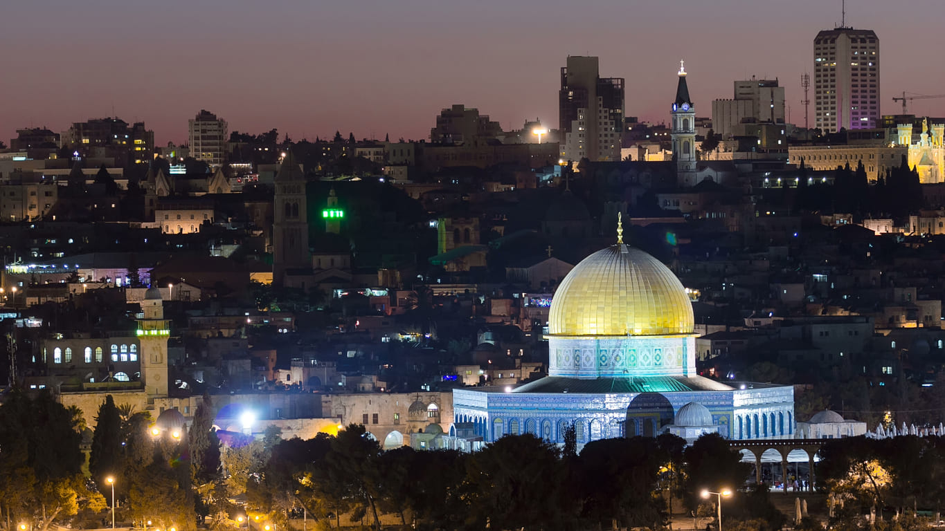 A night view of Jerusalem with the illuminated Dome of the Rock, near Al-Aqsa Mosque, a key site in the story of Isra' and Mi'raj.