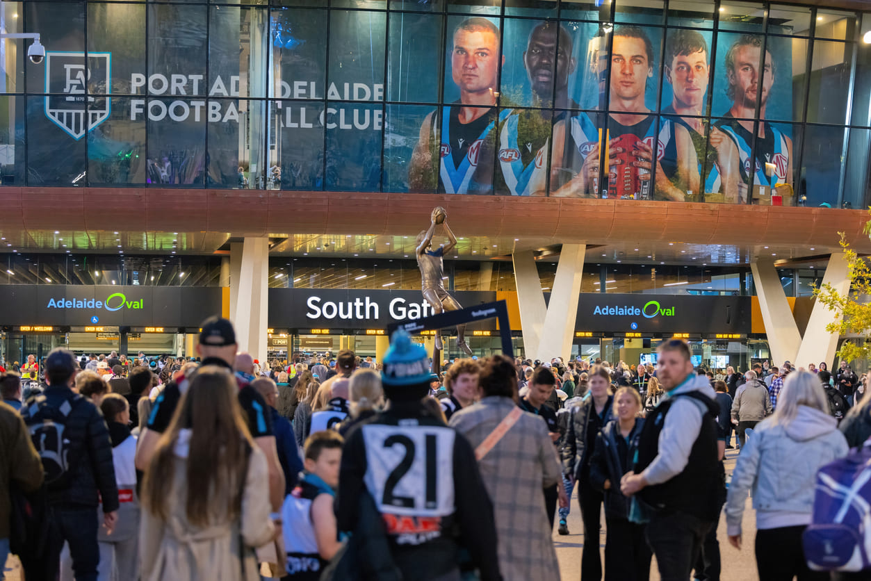 A lively crowd gathers at Adelaide Oval for an AFL match, celebrating the King's Birthday long weekend with one of Australia's favorite sports.