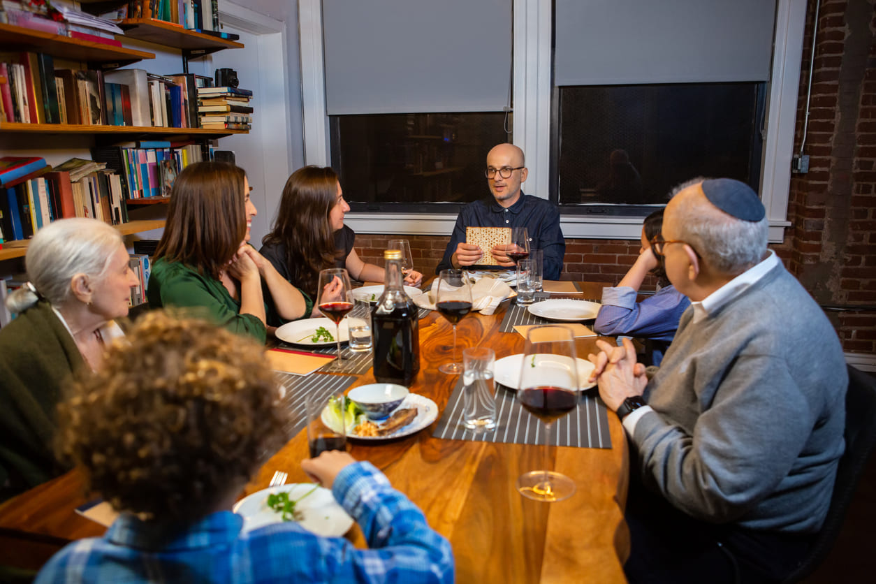 A multi generational family sits around a dinner table sharing stories and symbolic foods, capturing the warmth and tradition of Passover's final day.