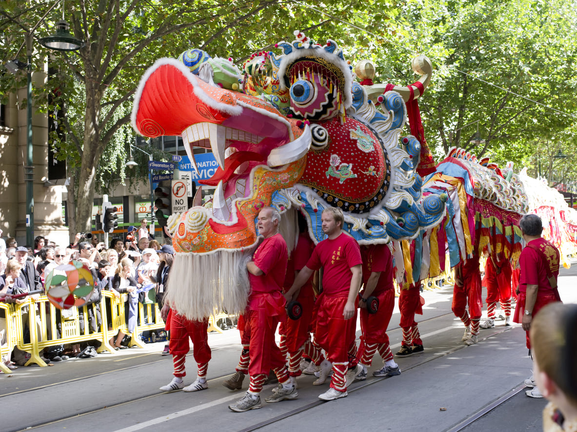A colorful dragon parade winds through the streets, with performers and crowds celebrating Lunar New Year in Australia with energy and tradition.