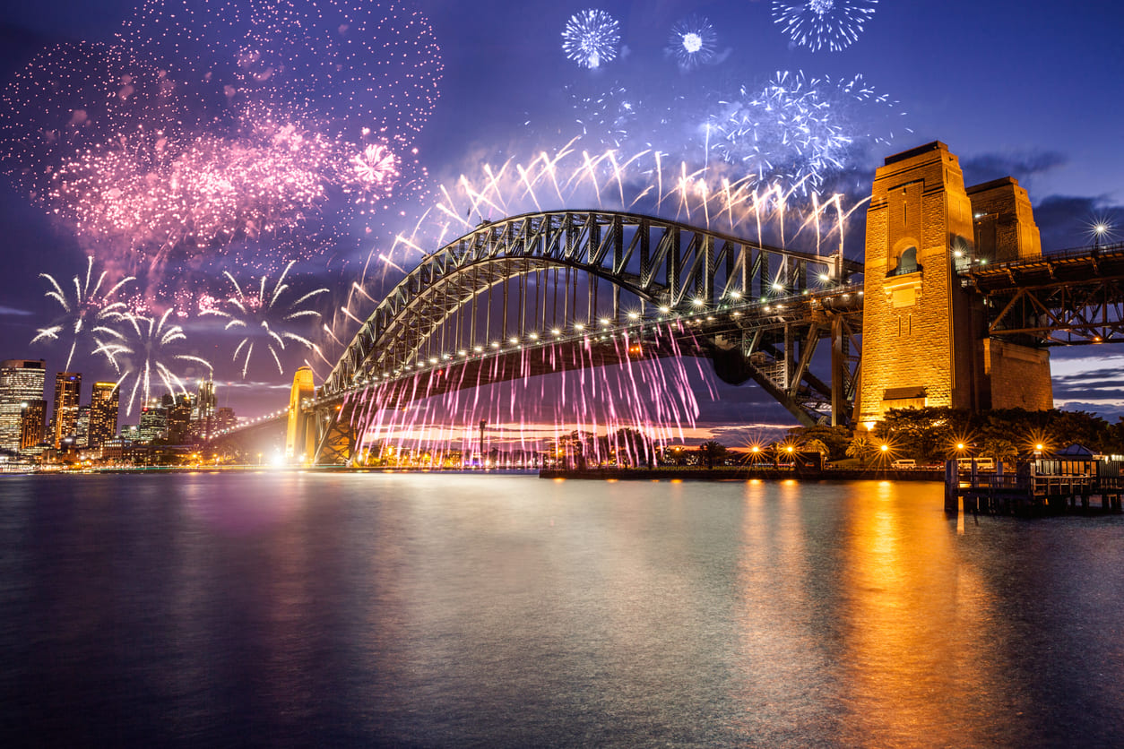 A breathtaking display of fireworks illuminates Sydney Harbour and the iconic Harbour Bridge, celebrating New Year's Eve in Australia.