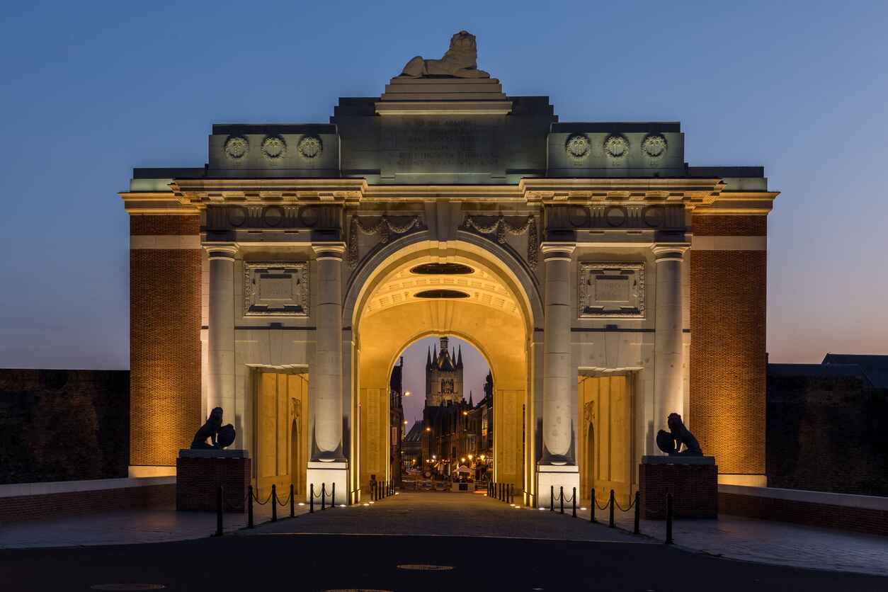 The Menin Gate in Ypres, beautifully lit at dusk, serves as a poignant memorial dedicated to the soldiers who lost their lives in World War I.