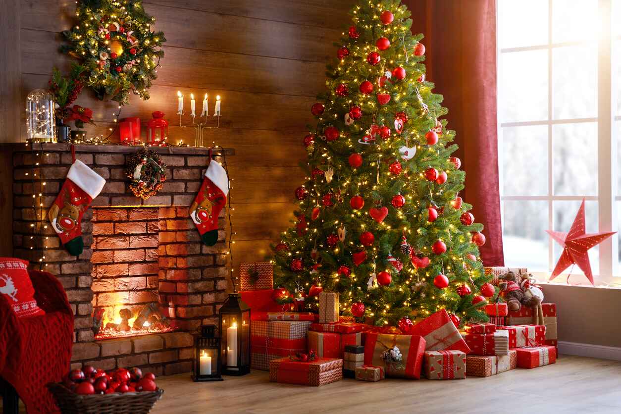 A cozy Christmas setting with a glowing fireplace, decorated tree, and festive gifts.
