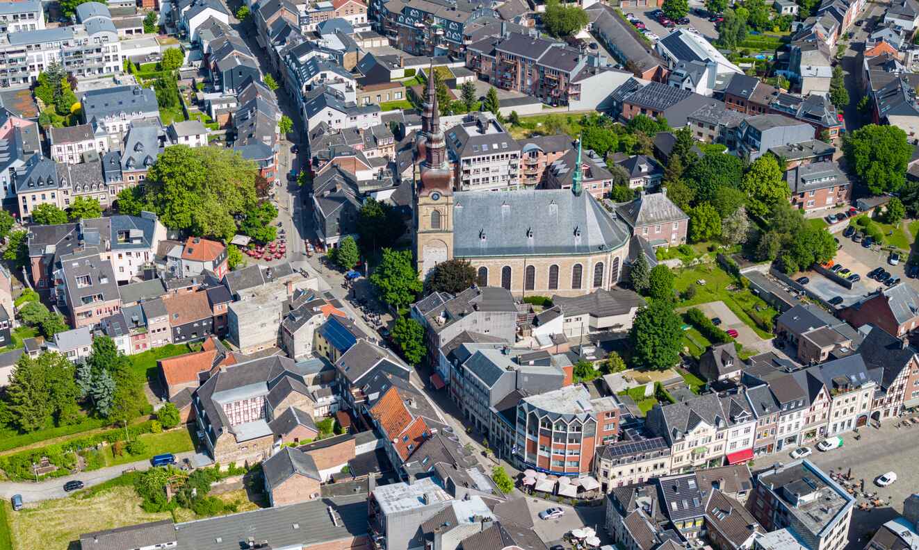 An aerial view of Eupen, showcasing its historic architecture, lush greenery, and central church, representing the heart of Belgium's German-speaking Community.