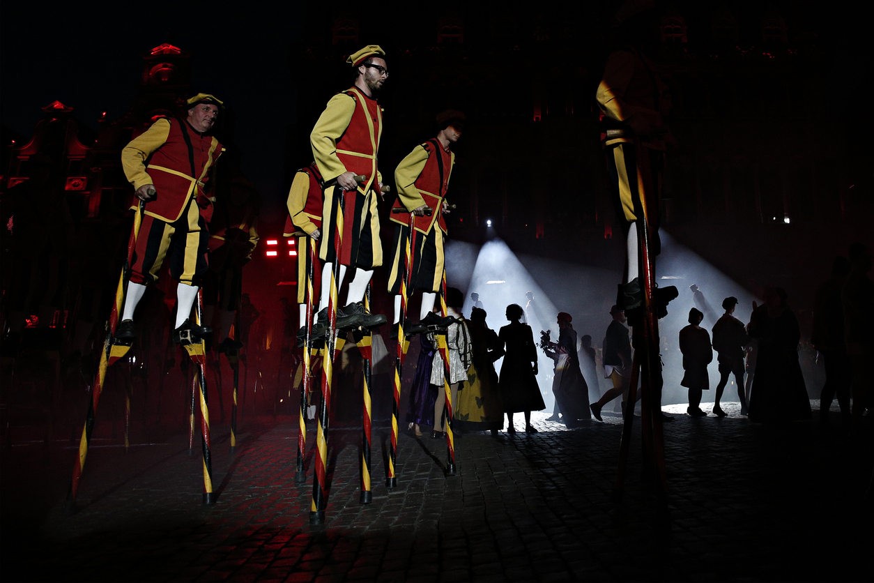 Stilt walkers in red and yellow perform during the Day of the Walloon Region celebrations.