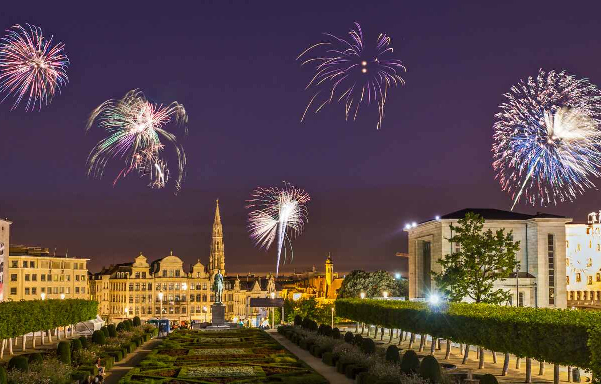 A stunning night view of Brussels illuminated by vibrant fireworks, celebrating the arrival of the New Year in a festive atmosphere.