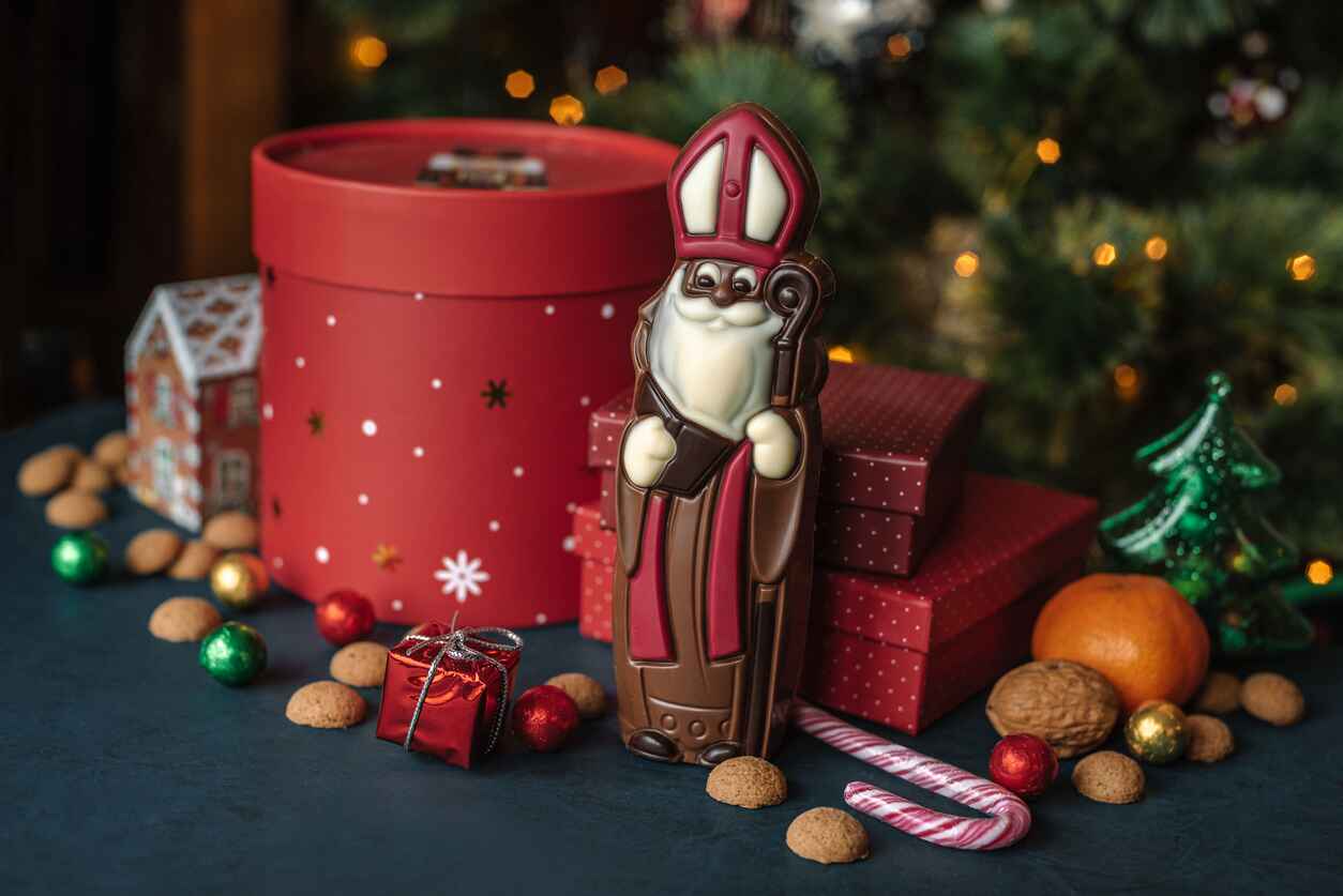 A St. Nicholas chocolate figure with festive treats and gifts, celebrating Sinterklaas in Belgium.