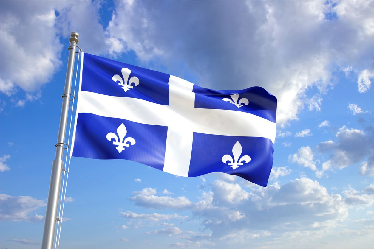 A vibrant Quebec flag flutters in the wind, representing the province's pride and historical significance on National Patriots' Day.