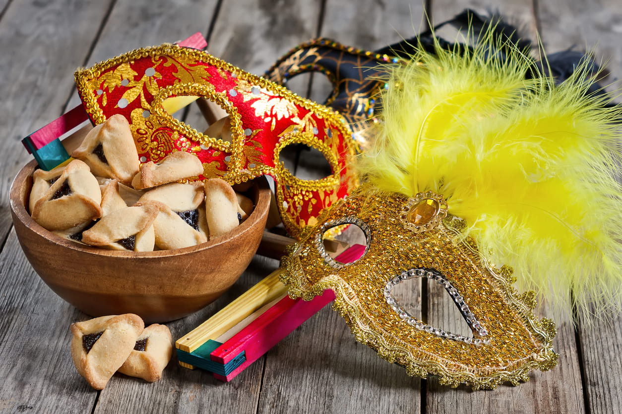 A vibrant Purim display featuring hamantaschen, decorative masks, and groggers, capturing the holiday's joy, traditions, and festive spirit.