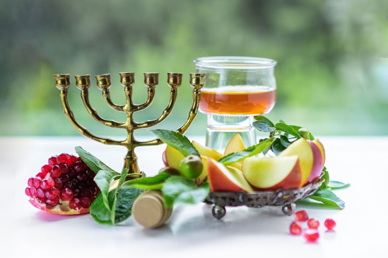 A festive Rosh Hashanah arrangement featuring apples, honey, and pomegranates, symbolizing a sweet and prosperous Jewish New Year.
