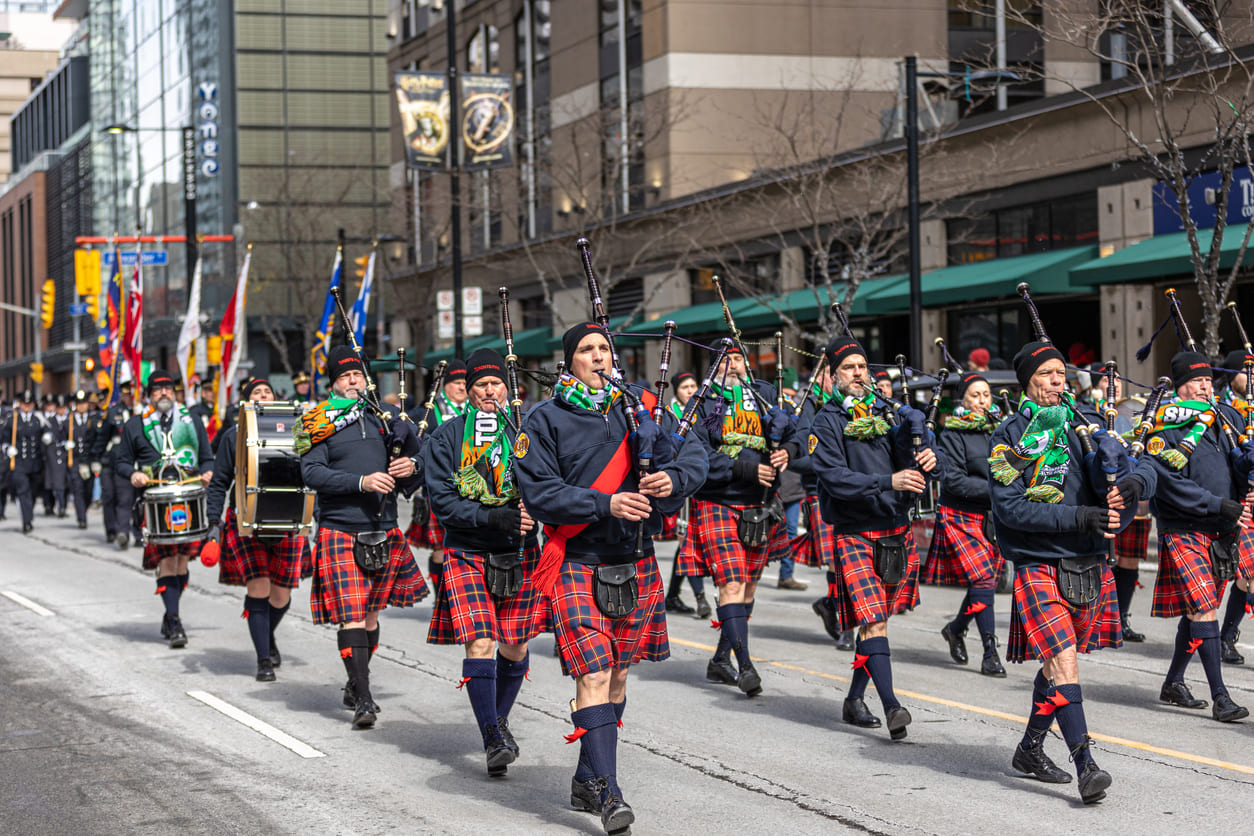The annual St. Patrick's Day parade in Toronto features a marching band dressed in traditional Scottish kilts, playing bagpipes as they move through the city streets.