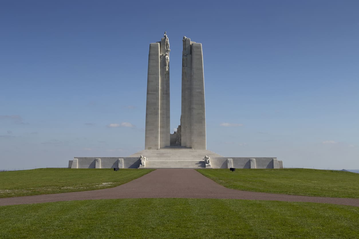 The Canadian National Vimy Memorial rises against a clear blue sky, honoring the sacrifice and bravery of Canadian soldiers in the Battle of Vimy Ridge.