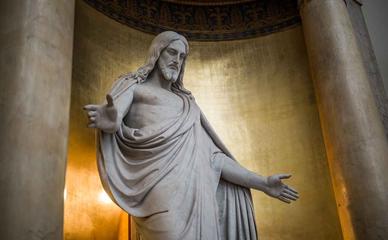 A majestic statue of Jesus Christ inside Copenhagen's Cathedral, with outstretched arms.