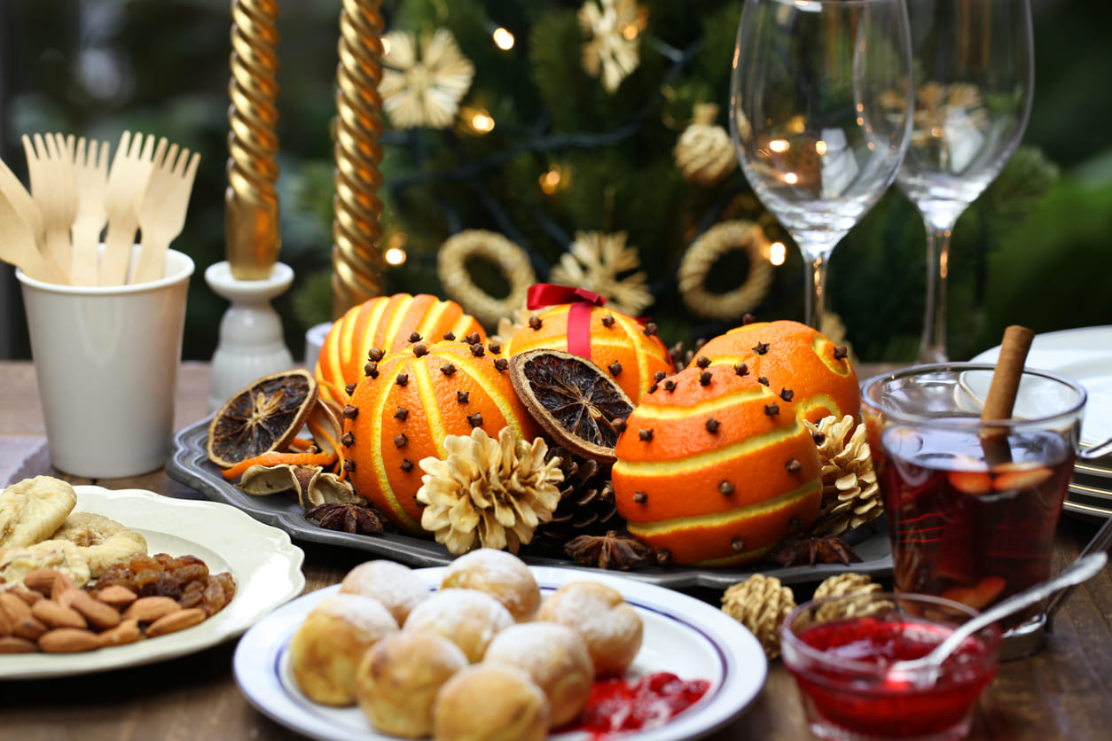 A festive Danish Christmas Eve table with æbleskiver, spiced oranges, nuts, and warm mulled wine.