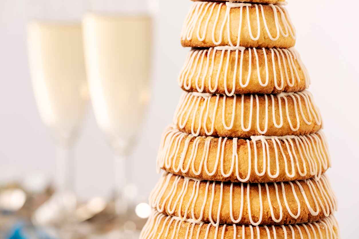 A towering stack of kransekage with two glasses of champagne.