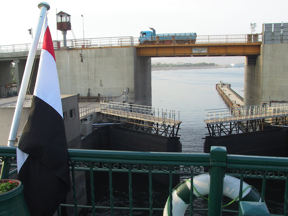 Nile floodgates in operation, with water flowing through a dam structure, symbolizing Egypt's modern approach to managing its lifeline river.