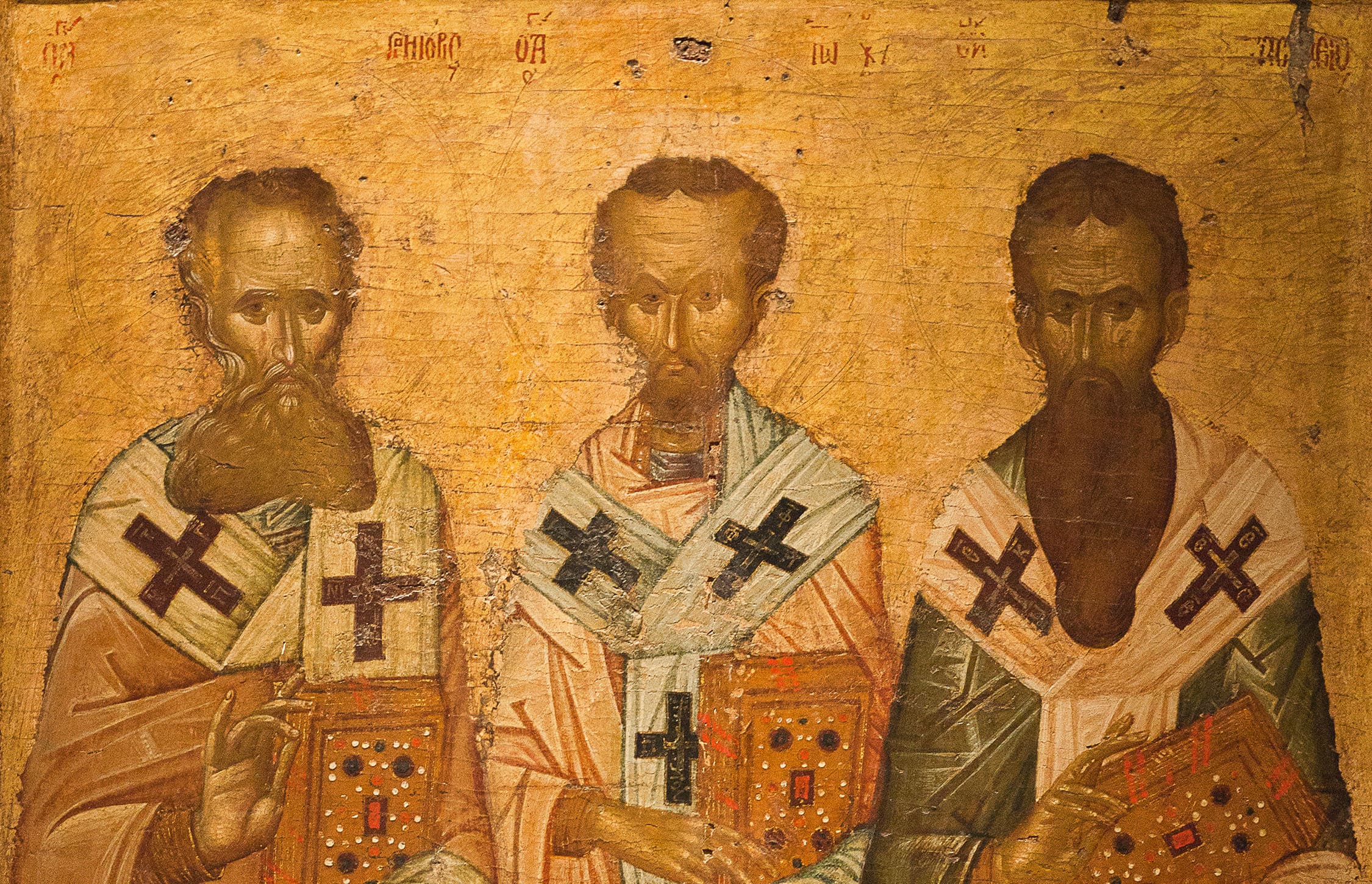 A 14th-century Byzantine icon depicts Basil the Great, Gregory the Theologian, and John Chrysostom in rich robes, standing side by side with scrolls and halos.