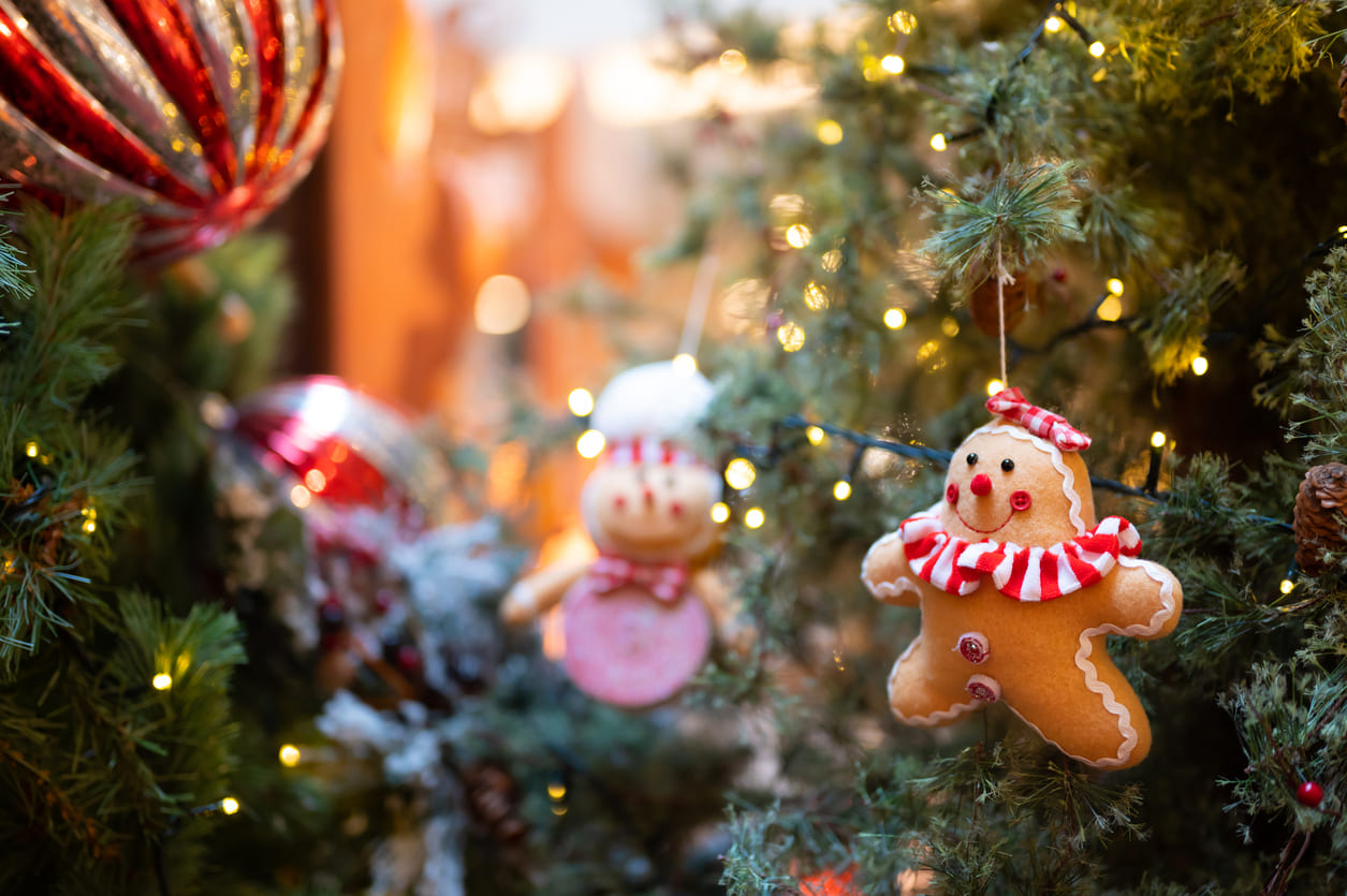 A decorated Christmas tree adorned with glowing lights and cute gingerbread ornaments, creating a warm and festive atmosphere.