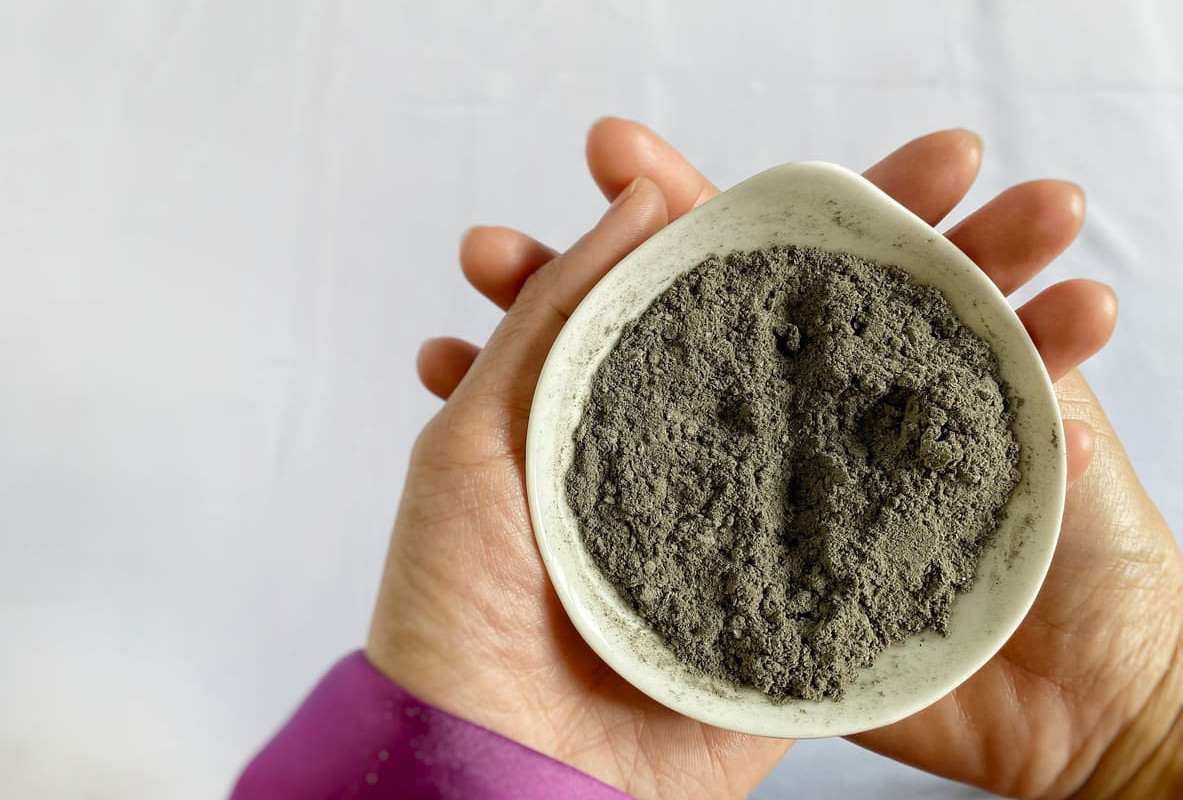 A person holding a small bowl filled with ashes, representing the symbolic ritual of Ash Wednesday in Mexico.