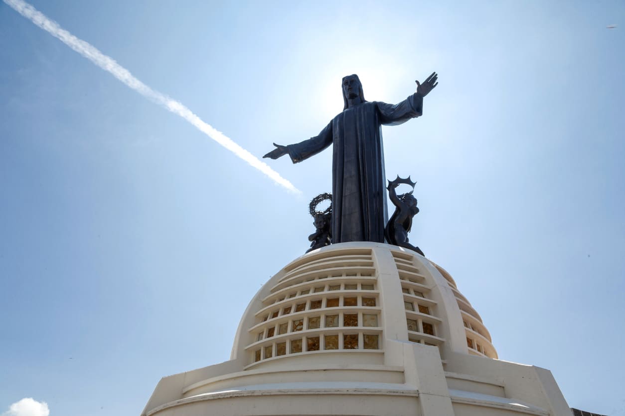 The towering Christ the King statue at Cerro del Cubilete, with arms outstretched against a bright sky, symbolizing peace and spiritual authority.