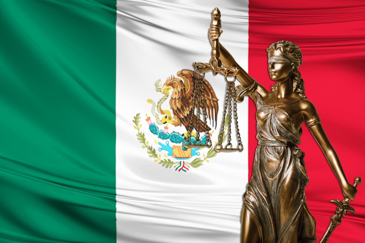 The statue of Lady Justice in front of the Mexican flag, symbolizing the nation's commitment to law, justice, and constitutional values.