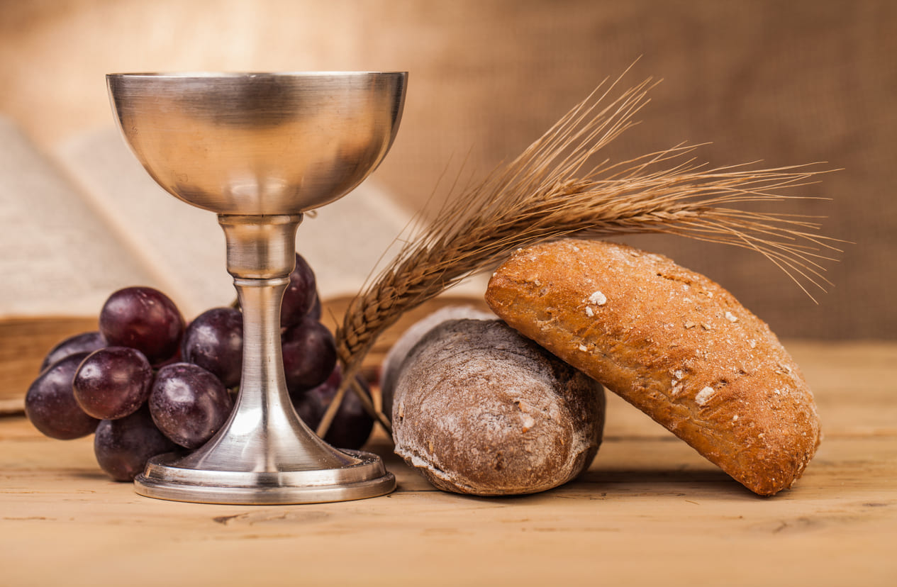 Bread, grapes, and a chalice arranged on a table, symbolizing the Last Supper and the spiritual meaning of Maundy Thursday.