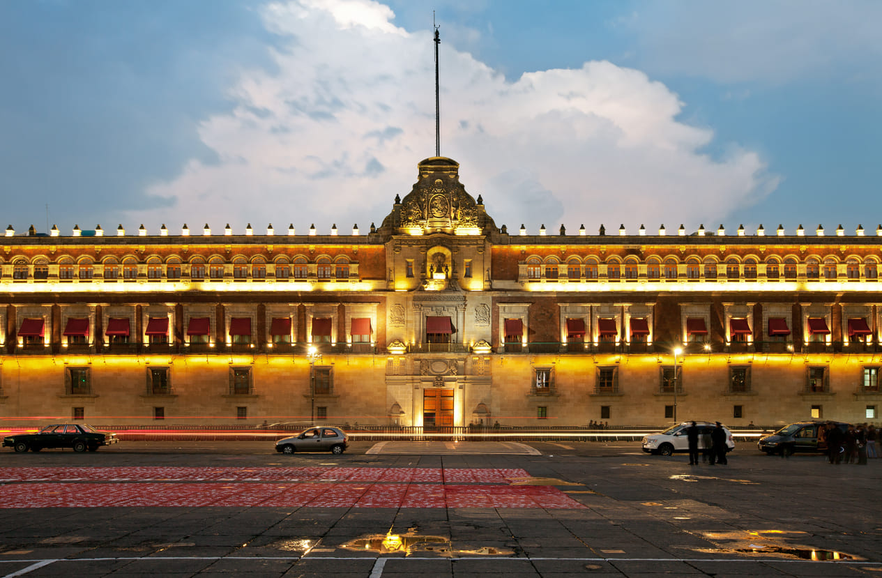 The National Palace in Mexico City, beautifully illuminated at night, with a clear view of its historic architecture.