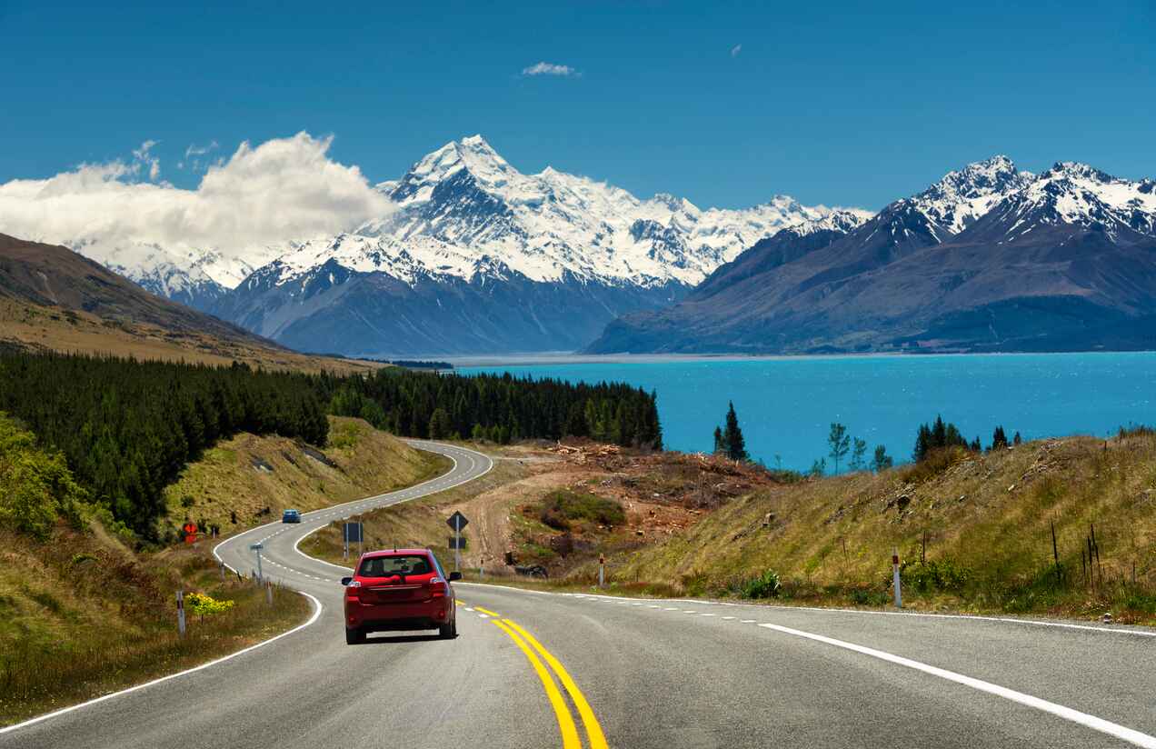 A scenic road leads to Lake Pukaki and the snow-capped Aoraki/Mount Cook, highlighting the majestic landscapes of South Canterbury.