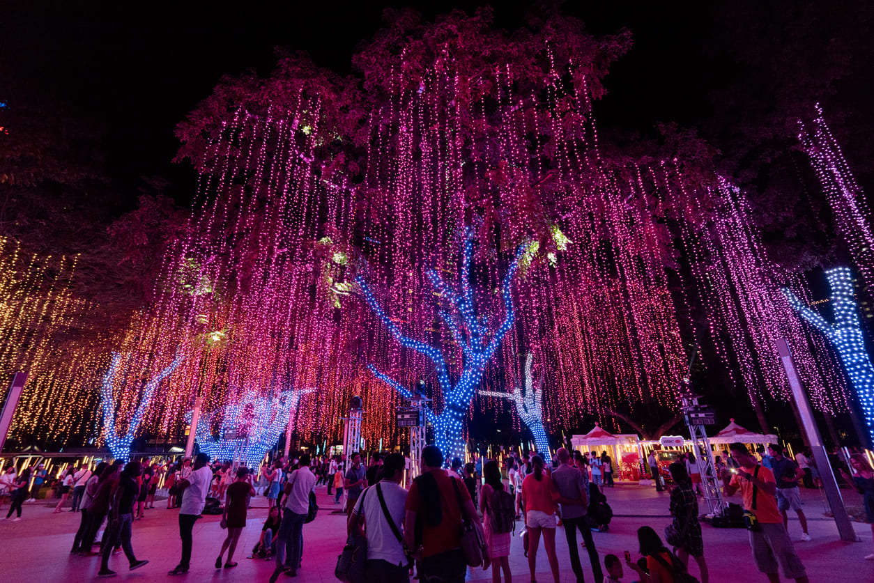 Families enjoying the vibrant Christmas lights display at Ayala Triangle Gardens in Manila, a festive highlight of the holiday season in the Philippines.
