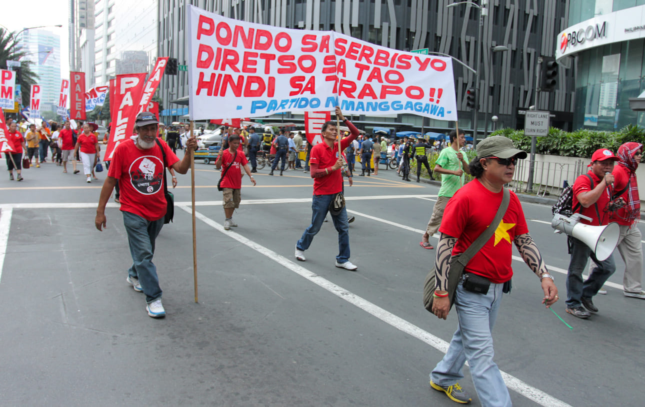 Workers march with banners and raised fists on Labor Day, filling the streets with calls for justice and reform.