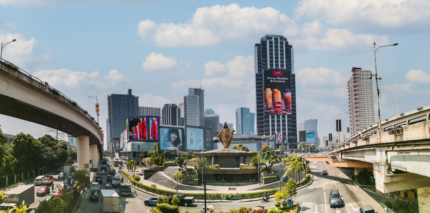 The EDSA Shrine surrounded by the busy streets of Metro Manila, marking the historic site of the 1986 People Power Revolution.