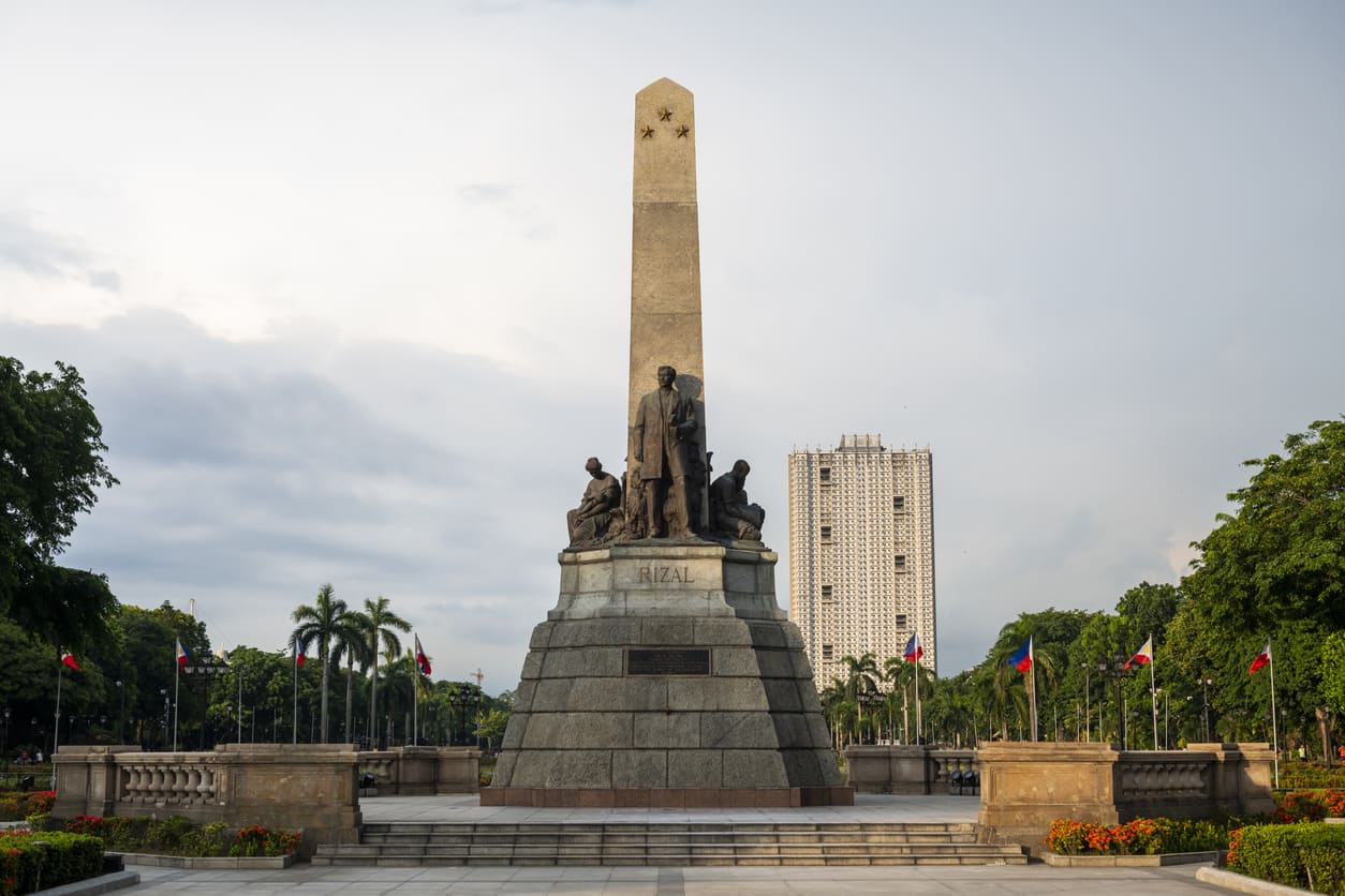 The iconic Rizal Monument rises proudly at Luneta Park, surrounded by flags and gardens, honoring the national hero's sacrifice and legacy.
