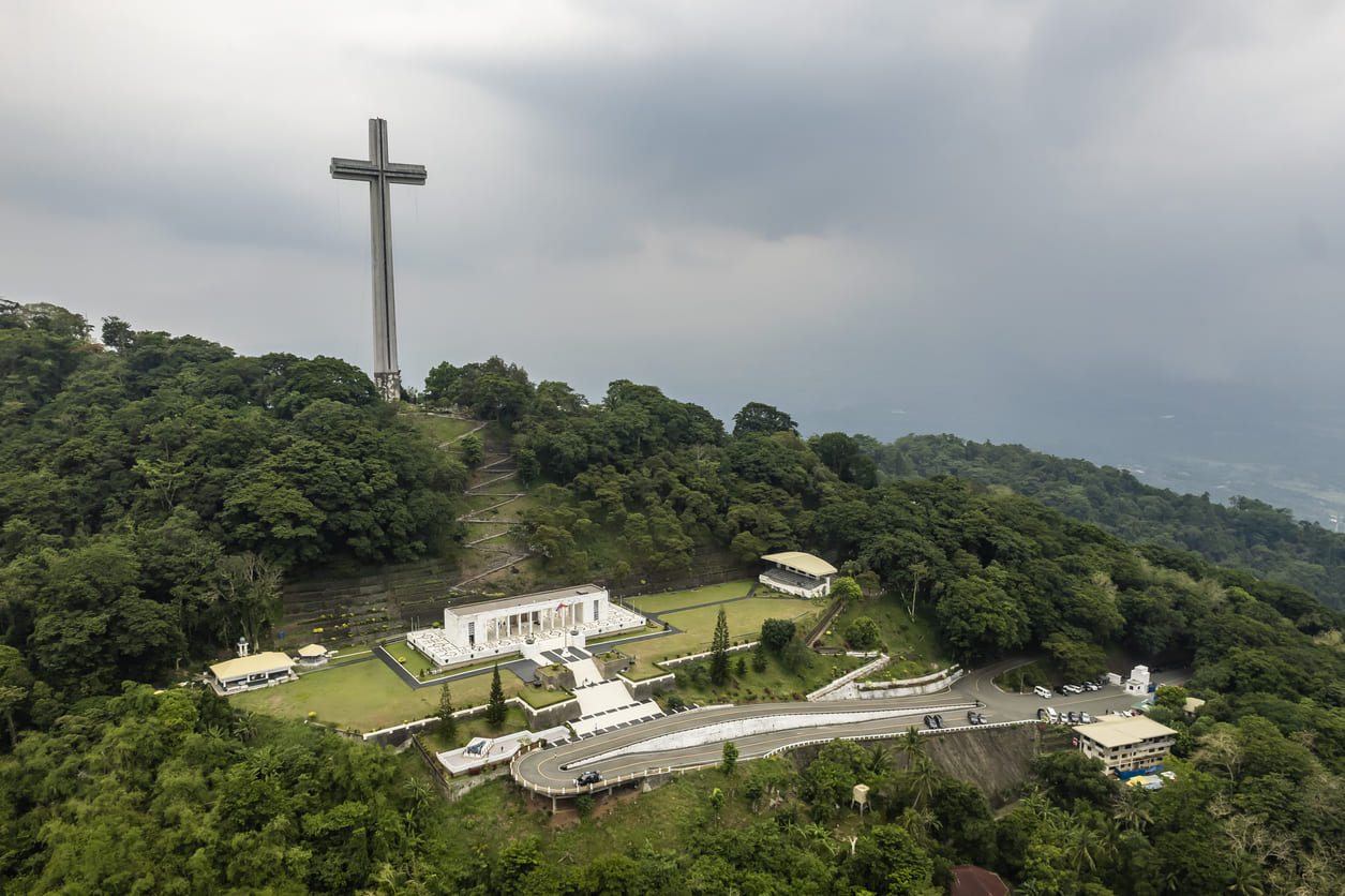 The Mount Samat National Shrine, crowned by a giant memorial cross, stands amidst lush hills in Bataan as a lasting symbol of bravery and sacrifice.