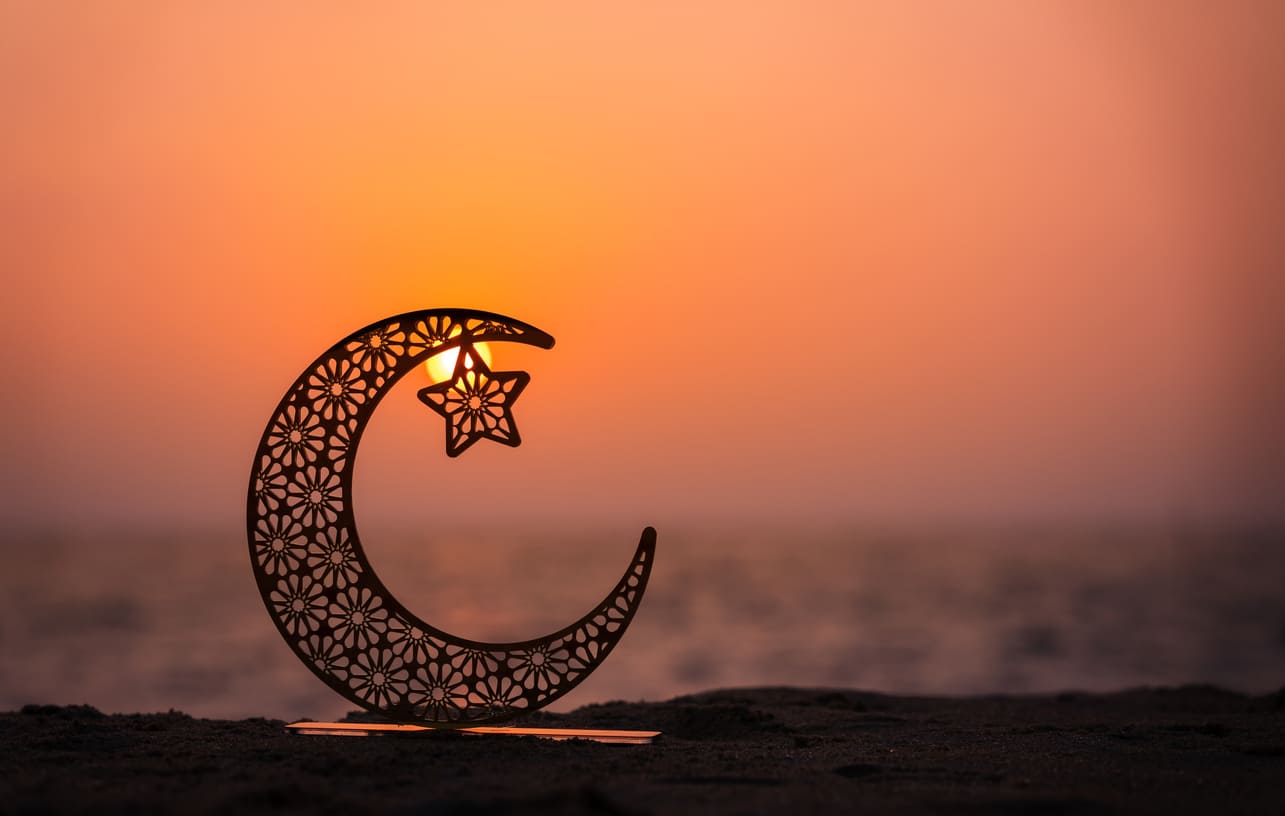 A decorative crescent moon and star set against a serene twilight sky, capturing the peaceful and spiritual essence of Ramadan.