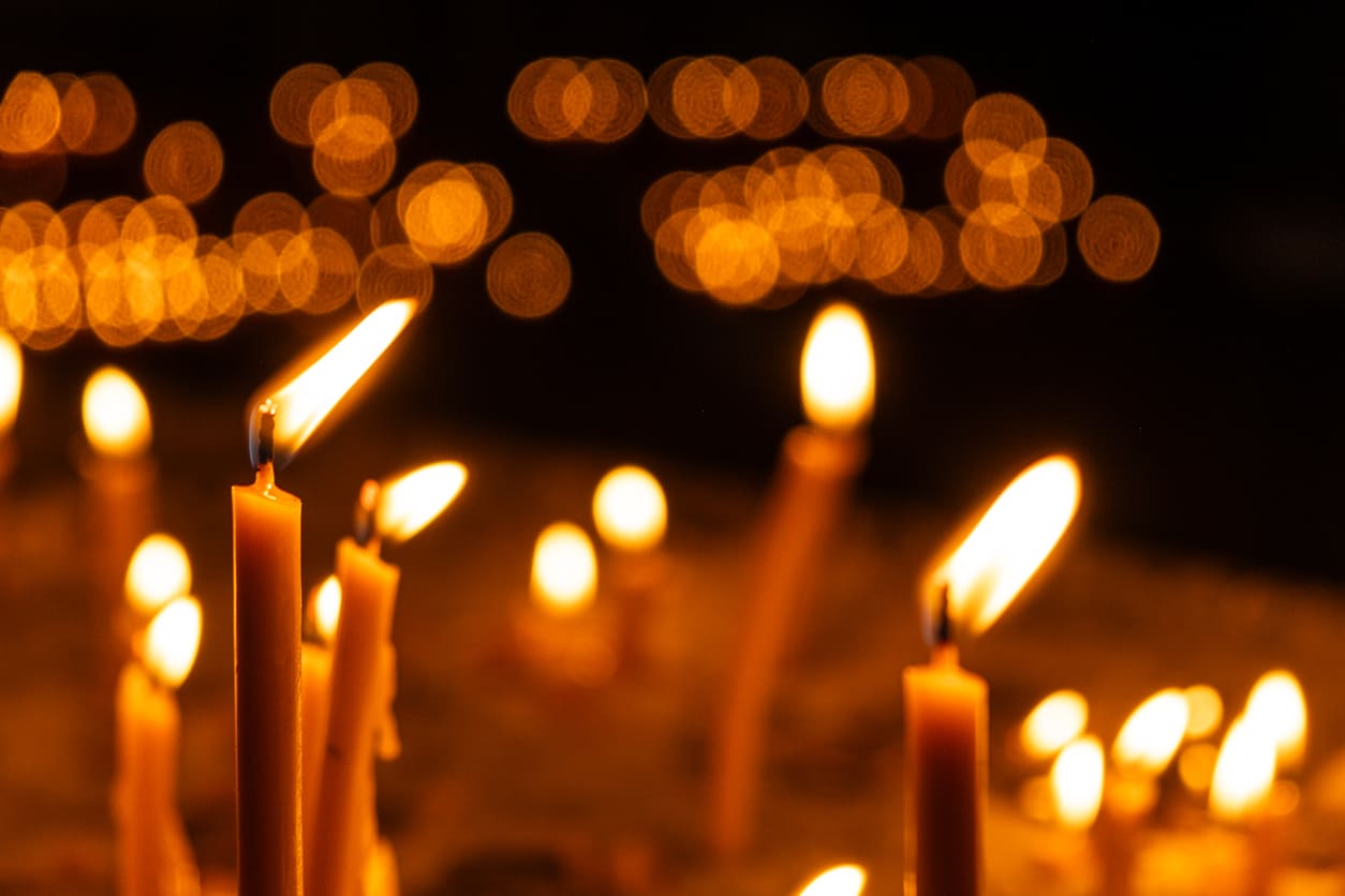 Softly glowing candles against a dark background, creating a peaceful and reflective atmosphere fitting for Easter Saturday.