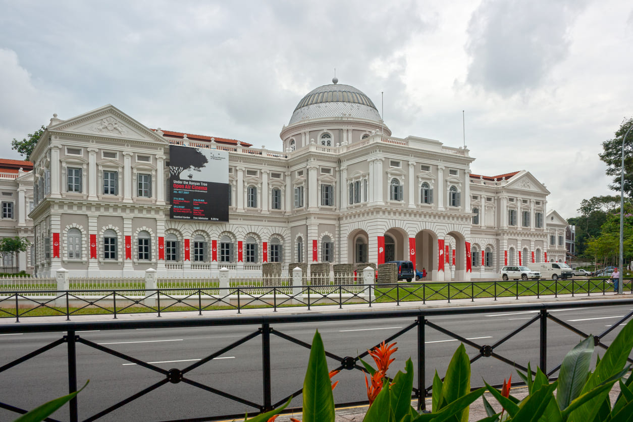 The elegant facade of the National Museum of Singapore, framed by clear skies and greenery, reflecting its role as a hub of culture and history.