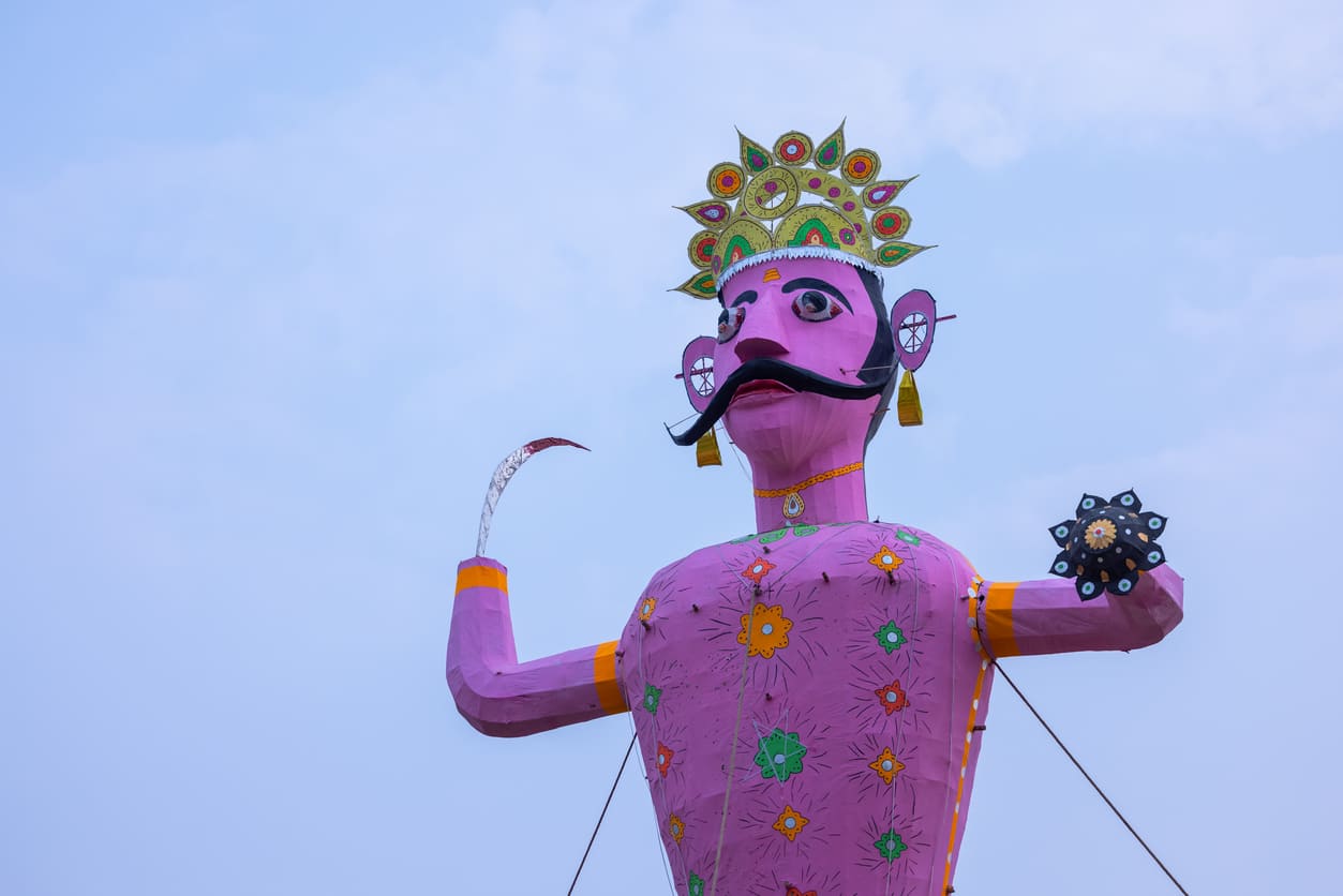 A large, vibrant effigy of Ravana with decorative details stands against the sky, representing the central figure of Dussehra festivities.