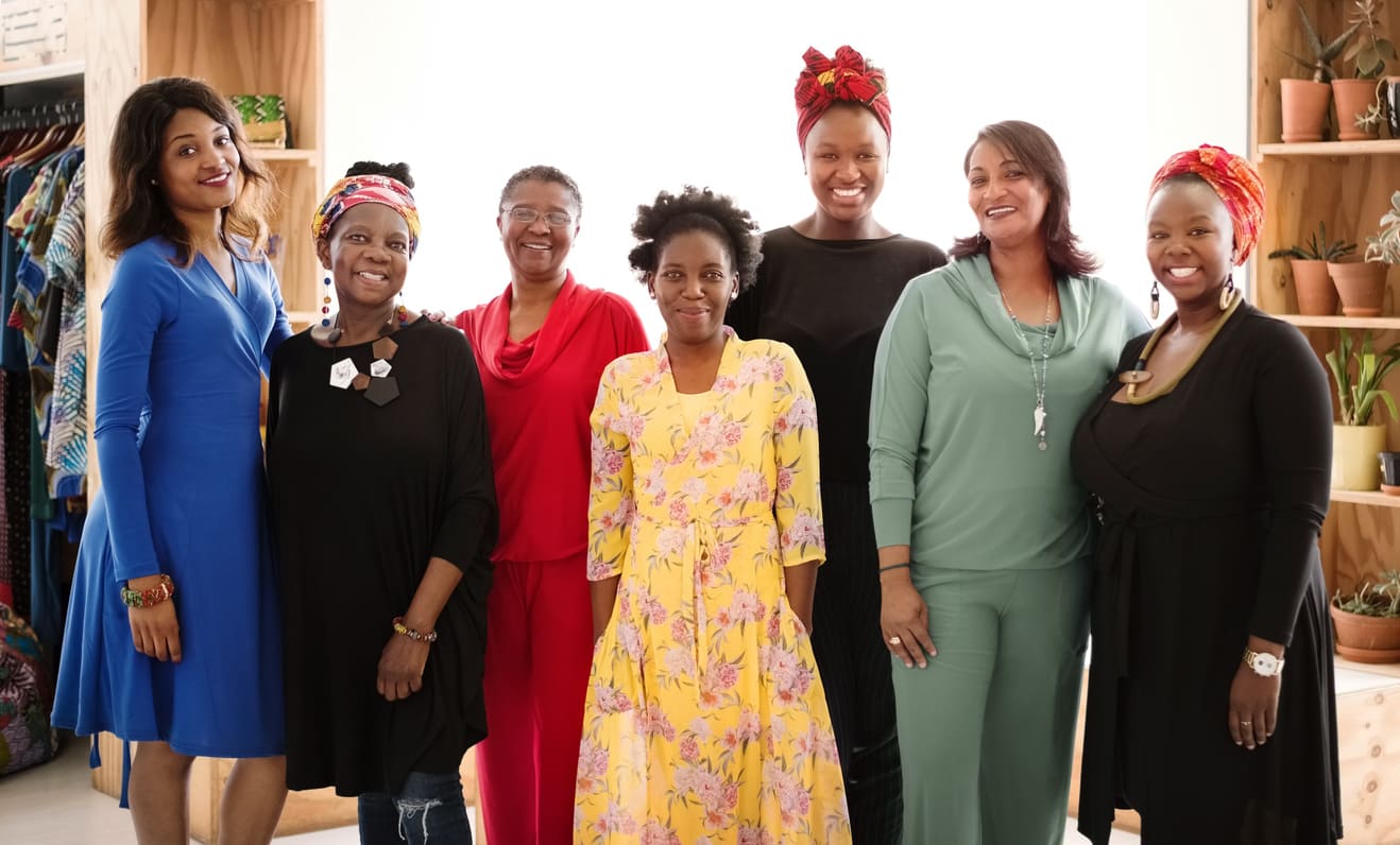 A joyful group of diverse women standing together outdoors, smiling and embracing the spirit of unity, pride, and empowerment.
