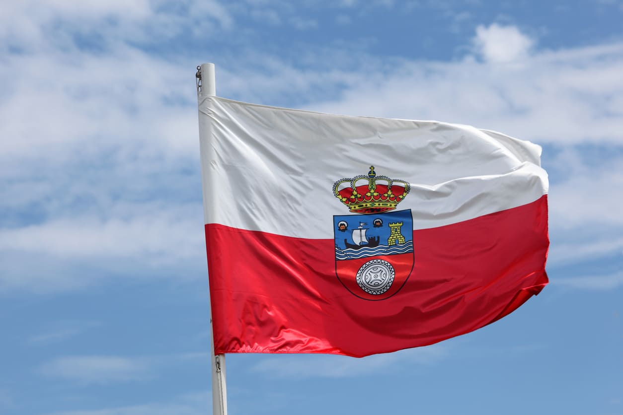 A vibrant Cantabrian flag flutters against a clear blue sky, representing the region's pride, history, and self-governance.