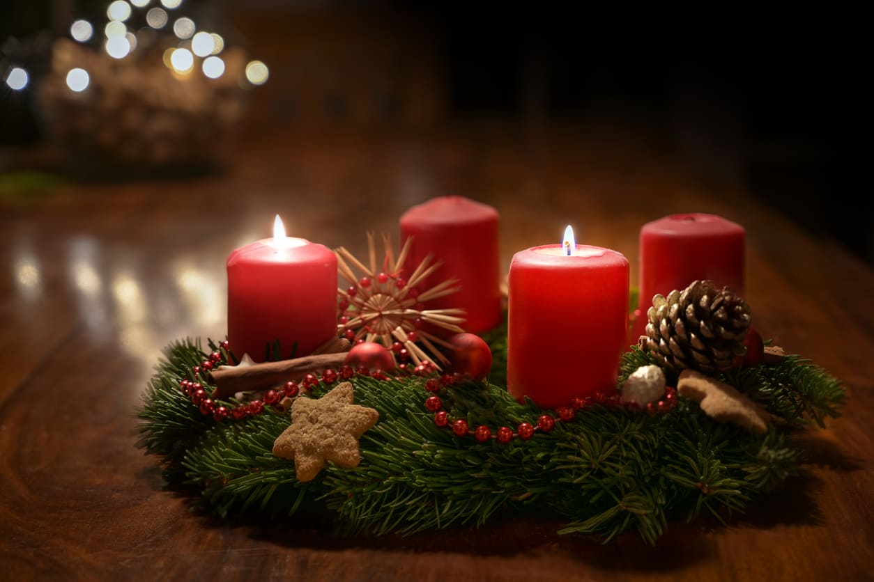 A festive Advent wreath with two lit red candles, pine branches, ornaments, and cookies, capturing the cozy tradition of Second Advent Sunday in Sweden.