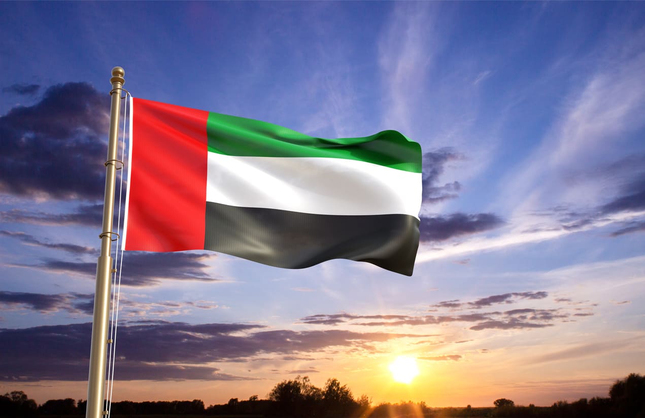 The UAE flag waving against a sunset sky, capturing the patriotic spirit of National Day.